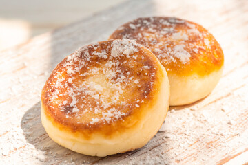 Two cheesecakes on a wooden aged white board in the sunlight. Food photo.
