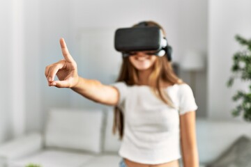 Adorable girl playing video game using vr goggles at home