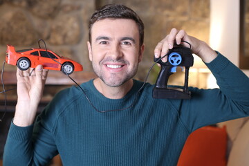 Man holding 1980s toy car with wired control