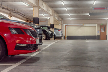Red car parked in a busy parking station. Urban high car density and high cost of keeping...