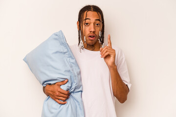 Young African American man wearing a pajama isolated on white background having some great idea, concept of creativity.