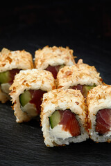 Japanese restaurant menu photo, seafood, national cuisine. Tuna and cheese sushi rolls set served on black plate, food background