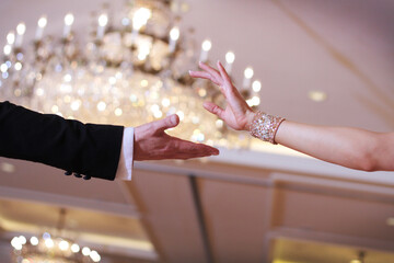 Closeup shot in black and white of the dance couple's hands while dancing a waltz