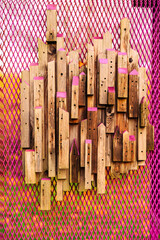 An insect hotel, also known as a bug hotel or insect house, is a manmade structure created to provide shelter for insects. This insect hotel is built of wooden structures on a pink mesh fence