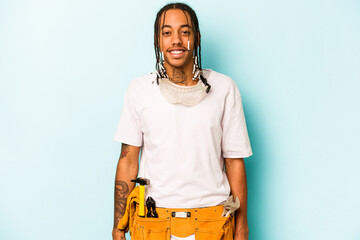 Young mechanic African American man isolated on blue background happy, smiling and cheerful.