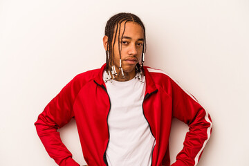Young African American man isolated on white background frowning face in displeasure, keeps arms...
