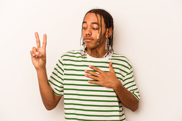 Young African American man isolated on white background taking an oath, putting hand on chest.