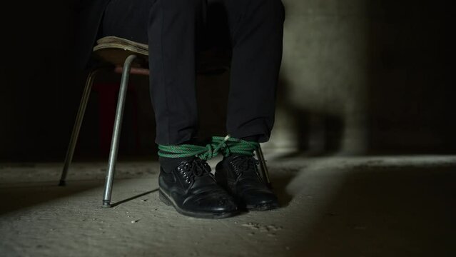 The male hostage was caught in a chair by the assailant. Trying to resist being tied to a rope at his feet, he will let the rope loose. In prison