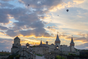 Kamianets-Podilskyi Castle and hot air balloons on sunset, Ukraine