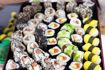 various sushi are beautifully laid out on a tray
