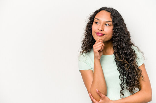 Young Hispanic Woman Isolated On White Background Looking Sideways With Doubtful And Skeptical Expression.
