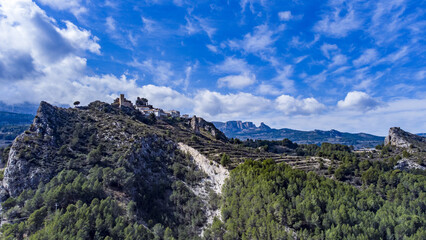 Bird's eye panoramic view of Castle San Jose and Guadalest town in bright sunlight, Alicante, Spain