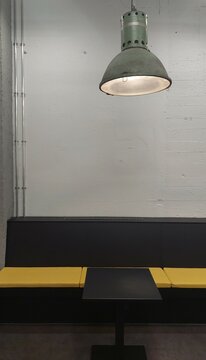 schwarzer Tisch mit gelber Sitzbank in Kantine mit Industrielampe 