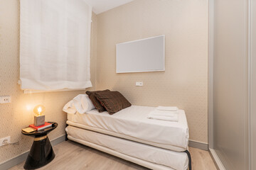 Youth bedroom with bedding, built-in wardrobe with gray sliding doors and wooden floors, white...