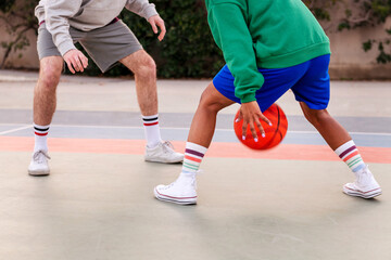 Fototapeta premium legs of two unrecognizable friends playing basket