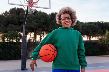 smiling latin woman in a basketball court