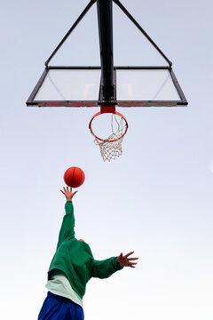 Woman Shooting In Basketball Hoop Seen From Below