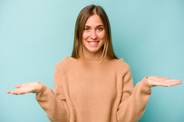 Young caucasian woman isolated on blue background makes scale with arms, feels happy and confident.