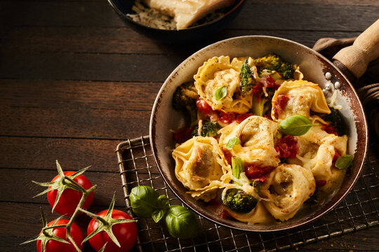 Yummy Italian tortelloni with broccoli and tomatoes in a hot frying pan