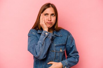 Young caucasian woman isolated on pink background blows cheeks, has tired expression. Facial...