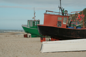 old boats stand on the beach by the sea.An old peeling fishing boat stands on the shore. A fishing...