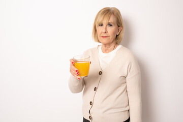 Portrait of senior woman holding orange juice glass Isolated over white Background