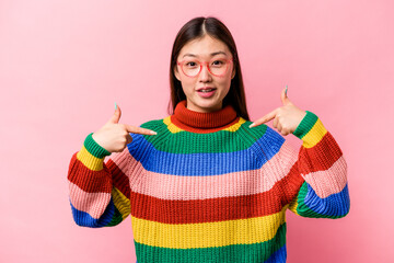 Young Chinese woman isolated on pink background points down with fingers, positive feeling.