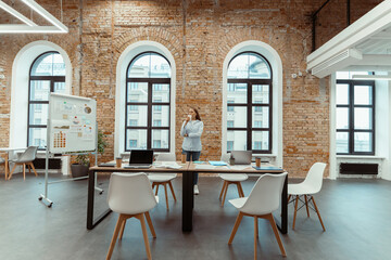 Young lady working in modern coworking in loft style