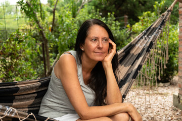 Woman sitting in a hammock and thinking