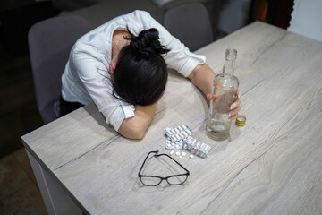 young woman preparing medication at home at the table exhausted, tired with alcohol