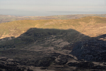 Fototapeta na wymiar Dark shadow of a Welsh mountain on the countryside of Snowdonia North Wales