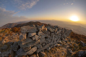 Snowdonia Wales mountain landscape with sunrise and old stone wall 
