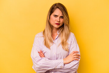 Fototapeta premium Young caucasian woman isolated on yellow background frowning face in displeasure, keeps arms folded.