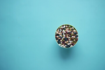 top view of mixed beans in a bowl on light green background 