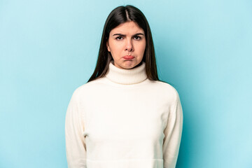 Fototapeta premium Young caucasian woman isolated on blue background sad, serious face, feeling miserable and displeased.