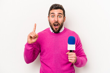 Young caucasian tv presenter man isolated on white background having an idea, inspiration concept.