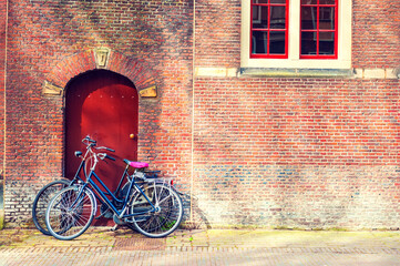 Two bicycles near the red brick wall. Amsterdam, Netherlands