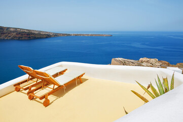 Chaise lounges on the terrace with sea view. Santorini island, Greece.. Travel and vacation
