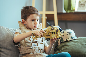 Little boy playing soldiers in living room. Child is playing with toy. Knights and battles -...