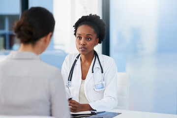 Any symptoms I should be aware of. Cropped shot of a female doctor talking to a patient in her office. - Powered by Adobe