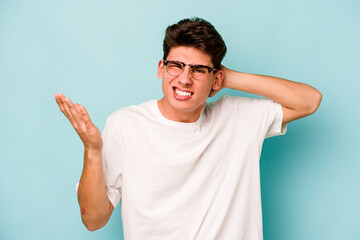 Young caucasian man isolated on blue background screaming with rage.