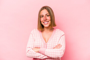 Fototapeta premium Young caucasian woman isolated on pink background who feels confident, crossing arms with determination.