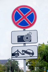 Traffic signs: car evacuation, no parking, surveillance camera. International traffic signs on a street. Transport and traffic infrastructure.