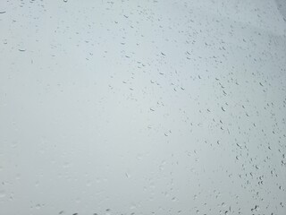 Raindrops on the window against gray sky