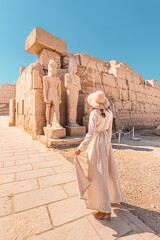 Woman traveler explores the ruins of the ancient Karnak temple in the city of Luxor in Egypt....