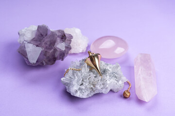 Crystal with pendulum on pink background  with quartz clusters for recreation and meditation....