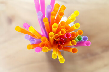 multi colored drinking straws on wooden table