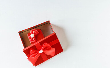 Red gift box  opened on white wooden table