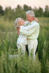 Portrait of beautiful senior couple relaxing and posing in the summer park