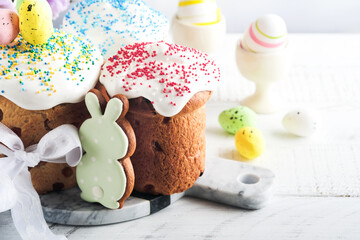 Traditional Easter sweet bread or cakes with white icing and sugar decor and quail eggs over white wooden table. Various Spring Easter cakes. Happy Easter day. Christian traditions. Top view.